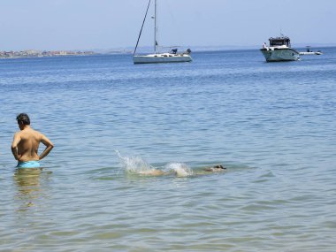 Portekiz 'deki Ribeira plajında banyo hareketleri. 26 Mayıs 2021, Cascais, Portekiz: Banyo güneşli bir günün tadını çıkarıyor Ribeira sahilinde, Cascais, Lizbon bölgesinin merkezinde, bu bahar çarşamba