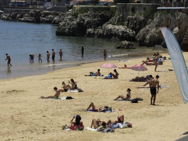 Portekiz 'deki Ribeira plajında banyo hareketleri. 26 Mayıs 2021, Cascais, Portekiz: Banyo güneşli bir günün tadını çıkarıyor Ribeira sahilinde, Cascais, Lizbon bölgesinin merkezinde, bu bahar çarşamba