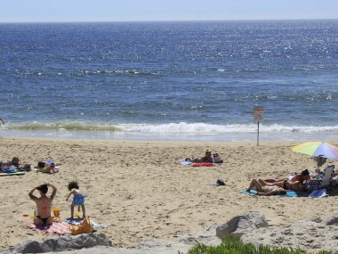 (INT) Banyo yapanlar, Portekiz 'in Costa da Caparica sahilinde güneşli bir günün tadını çıkarıyorlar. 8 Haziran 2021, Almada, Portekiz: Portekiz kıyısındaki Costa da Caparica plajında 8 Haziran Salı günü Avrupa kıtasındaki havuz temizleyicilerinin hareketi. Fotoğraf: Edson de Souza / Th
