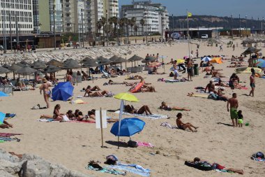 (INT) Banyo yapanlar, Portekiz 'in Costa da Caparica sahilinde güneşli bir günün tadını çıkarıyorlar. 8 Haziran 2021, Almada, Portekiz: Portekiz kıyısındaki Costa da Caparica plajında 8 Haziran Salı günü Avrupa kıtasındaki havuz temizleyicilerinin hareketi. Fotoğraf: Edson de Souza / Th