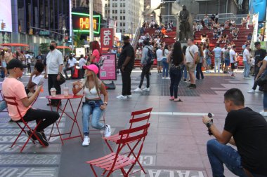 (New York 'ta güneşli ve mutlu bir gün. 10 Haziran 2021, New York, ABD: Hava güneşli ve sıcak olduğu için, pek çok New Yorklu ve turist bundan yararlanıyor ve Times Meydanı 'nda eğleniyor. 