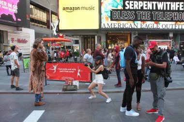 (New York 'ta güneşli ve mutlu bir gün. 10 Haziran 2021, New York, ABD: Hava güneşli ve sıcak olduğu için, pek çok New Yorklu ve turist bundan yararlanıyor ve Times Meydanı 'nda eğleniyor. 