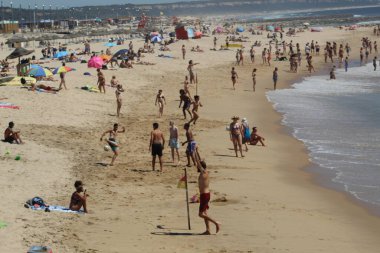 (INT) Banyo yapanlar, Portekiz 'in Costa da Caparica sahilinde güneşli bir günün tadını çıkarıyorlar. 8 Haziran 2021, Almada, Portekiz: Portekiz kıyısındaki Costa da Caparica plajında 8 Haziran Salı günü Avrupa kıtasındaki havuz temizleyicilerinin hareketi. Fotoğraf: Edson de Souza / Th