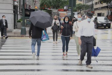 New York 'ta sabahın erken saatlerinde hafif yağmur yağar. 14 Haziran 2021, New York, ABD: New Yorklular Manhattan 'da sabahın erken saatlerinde yağmurla karşı karşıya kaldılar ve onları şemsiyelerini ve yağmur korumalarını kullanmaya zorladılar. Hava tahminine göre...