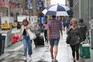 New York 'ta sabahın erken saatlerinde hafif yağmur yağar. 14 Haziran 2021, New York, ABD: New Yorklular Manhattan 'da sabahın erken saatlerinde yağmurla karşı karşıya kaldılar ve onları şemsiyelerini ve yağmur korumalarını kullanmaya zorladılar. Hava tahminine göre...