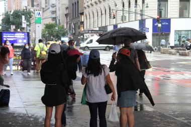 New York 'ta sabahın erken saatlerinde hafif yağmur yağar. 14 Haziran 2021, New York, ABD: New Yorklular Manhattan 'da sabahın erken saatlerinde yağmurla karşı karşıya kaldılar ve onları şemsiyelerini ve yağmur korumalarını kullanmaya zorladılar. Hava tahminine göre...
