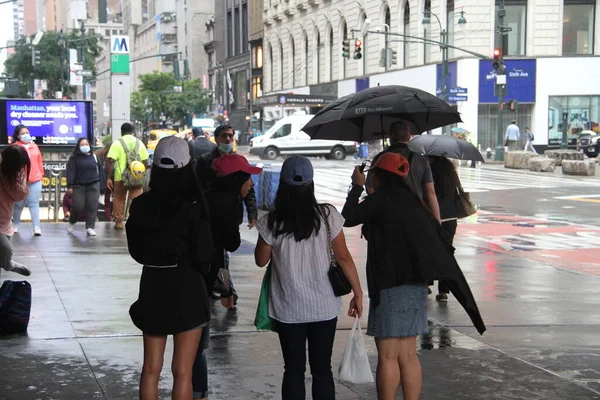New York 'ta sabahın erken saatlerinde hafif yağmur yağar. 14 Haziran 2021, New York, ABD: New Yorklular Manhattan 'da sabahın erken saatlerinde yağmurla karşı karşıya kaldılar ve onları şemsiyelerini ve yağmur korumalarını kullanmaya zorladılar. Hava tahminine göre...