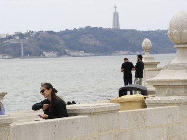 Portekiz 'de turizm. 16 Haziran 2021, Lizbon, Portekiz. Turistler 16 Çarşamba günü Portekiz 'in başkenti Lizbon' daki Comercio Meydanı önündeki Tejo Nehri 'nin keyfini çıkarıyorlar.). 