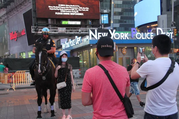 Kalabalık Times Meydanı COVID-19 'un ortasında. 15 Haziran 2021 'de, New York, ABD: Times Meydanı çoğunlukla sosyal uzaklık ve maske kullanımı olmayan bir sürü insanla dolup taşıyor. İnsanlar eğlenirken görülüyor.