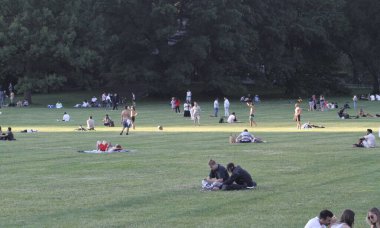 (New Yorklular Central Park Çimenliği. 17 Haziran 2021, New York, ABD: Güneşli bir günde New York 'lular ve turistler Central Park çimlerini doldururken, piknik yaparken, dans ederken, spor yaparken, roman okurken ve partnerleriyle aşk zamanlarının keyfini çıkarırken görülüyor.