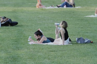 (New Yorklular Central Park Çimenliği. 17 Haziran 2021, New York, ABD: Güneşli bir günde New York 'lular ve turistler Central Park çimlerini doldururken, piknik yaparken, dans ederken, spor yaparken, roman okurken ve partnerleriyle aşk zamanlarının keyfini çıkarırken görülüyor.