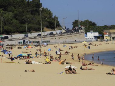 Yüzenler, Oeiras 'taki Santo Amaro plajında güneşli bir günün tadını çıkarıyorlar. 28 Haziran 2021, Oeiras, Portekiz: Oeiras 'ın Oeiras ilçesindeki Santo Amaro plajında hamamlar, koronavirüs salgınının ortasında, 28 Haziran Pazartesi günü.