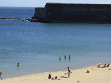 Yüzenler, Oeiras 'taki Santo Amaro plajında güneşli bir günün tadını çıkarıyorlar. 28 Haziran 2021, Oeiras, Portekiz: Oeiras 'ın Oeiras ilçesindeki Santo Amaro plajında hamamlar, koronavirüs salgınının ortasında, 28 Haziran Pazartesi günü.