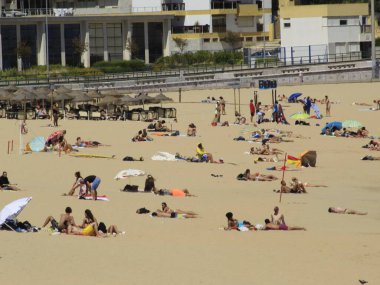 Yüzenler, Oeiras 'taki Santo Amaro plajında güneşli bir günün tadını çıkarıyorlar. 28 Haziran 2021, Oeiras, Portekiz: Oeiras 'ın Oeiras ilçesindeki Santo Amaro plajında hamamlar, koronavirüs salgınının ortasında, 28 Haziran Pazartesi günü.