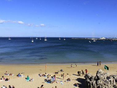 Ribeira sahilinde, Cascais 'de hareket var. 7 Temmuz 2021, Cascais, Portekiz. Ribeira sahilinde, Cascais şehrinde, küçük bir plaj, ama spor için çok kullanılıyor ve restoranlara ve Cascais 'e yakın. 