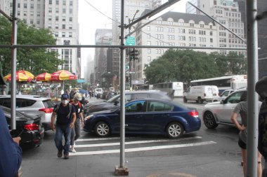 New Yorklular Manhattan 'da yoğun trafik ve yağış ile karşılaştı. 19 Temmuz 2021, New York, ABD: Şiddetli trafik ve hafif yağmurla karşı karşıya kalan New Yorklular bu öğleden sonra Manhattan bölgesindeki caddeleri geçmekte güçlük çektiler.