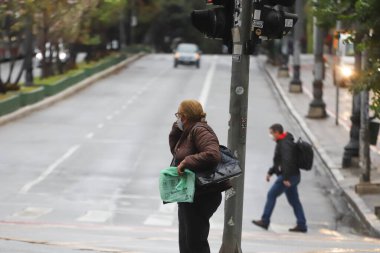 Yayalar kendilerini Sao Paulo 'da yağış ve soğuktan korur. 28 Temmuz 2021, Sao Paulo, Brezilya: Yoğun bir kutup hava kütlesiyle bağlantılı olarak, yeni bir soğuk hava cephesinin ilerlemesi Güney 'deki sıcaklıkları azaltmalı