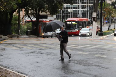 Yayalar kendilerini Sao Paulo 'da yağış ve soğuktan korur. 28 Temmuz 2021, Sao Paulo, Brezilya: Yoğun bir kutup hava kütlesiyle bağlantılı olarak, yeni bir soğuk hava cephesinin ilerlemesi Güney 'deki sıcaklıkları azaltmalı