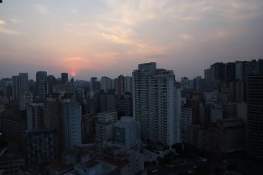 Sao Paulo 'da günbatımı. 26 Ağustos 2021, Sao Paulo, Brezilya: Sao Paulo 'nun merkezinden 26 Ağustos Perşembe günü öğleden sonra görülen gün batımı, yoğun sıcak ve düşük görece nemli bir günde. 