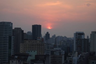 Sao Paulo 'da günbatımı. 26 Ağustos 2021, Sao Paulo, Brezilya: Sao Paulo 'nun merkezinden 26 Ağustos Perşembe günü öğleden sonra görülen gün batımı, yoğun sıcak ve düşük görece nemli bir günde. 