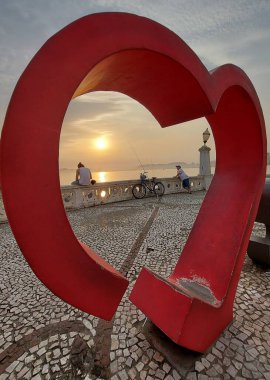 Yüzenler Santos sahilinde gün batımını seyrediyorlar. 8 Eylül 2021, Santos, Sao Paulo, Brezilya: Sao Paulo 'nun güney kıyısındaki Ponta da Praia' nın alçak duvarında 8 Eylül Çarşamba günü gün batımını izleyen banyolar), 