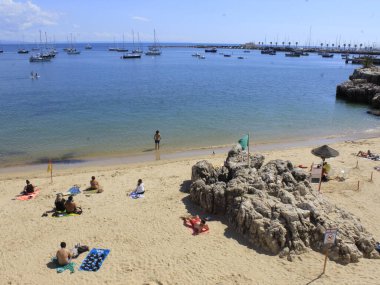 Cascais 'deki Rainha plajında hareketlilik var. 23 Eylül 2021, Cascais, Portekiz: 23 Eylül Perşembe günü, sonbaharın ortasında sıcak bir günde bile, Portekiz kıyısındaki Cascais 'deki Rainha plajında çok az sayıda yüzücü cesaret gösterdi.). 