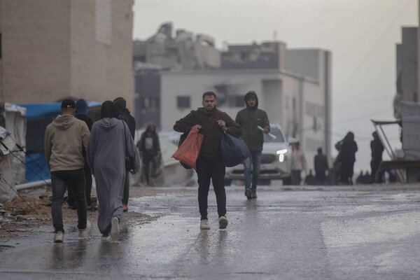Палестинские семьи ходят под ливнем, как зима в Газе. Газа, Палестина 14 ноября 2025 года