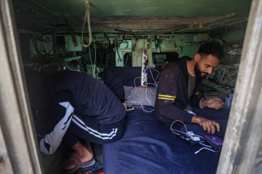 Gazan Gençliği, Gazze Şeridi 'nde ailesini kaybettikten sonra Terk Edilmiş Zırhlı Araç' ı Güneş Şarj İstasyonu 'na çevirdi. 30 Kasım 2025, Gazze, Filistin (mohammed skaik / the new ws2)