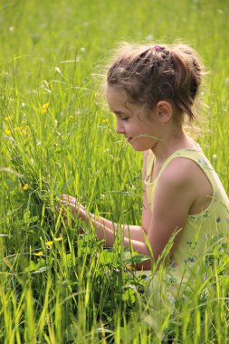 Yeşil çimenlerde oturan kız