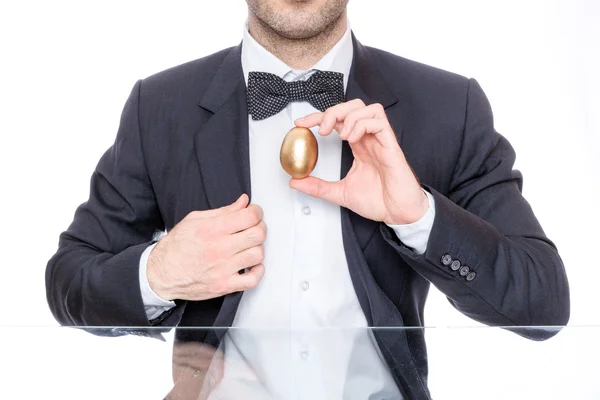 Homem segurando um ovo de ouro para a Páscoa Imagem De Stock