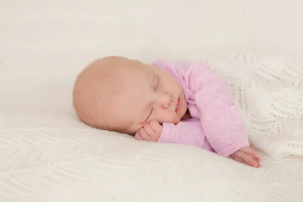 Newborn baby sleeping covered with a white blanket satisfied — Stock Photo, Image