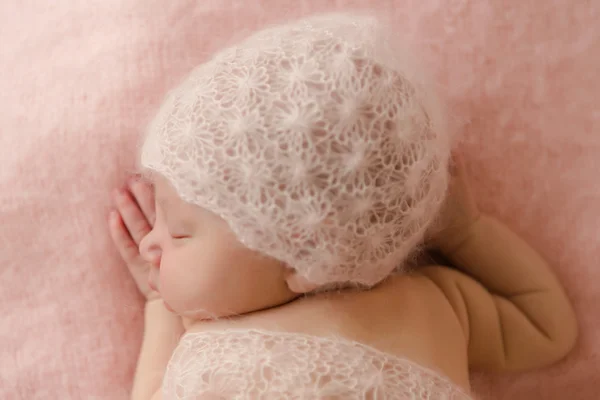 Bebé recién nacido durmiendo sobre su estómago cubierto con una manta y una gorra en su cabeza rosa —  Fotos de Stock