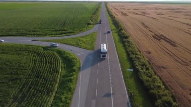 Tarlaların ortasındaki bir otoyolda giden kamyonlar