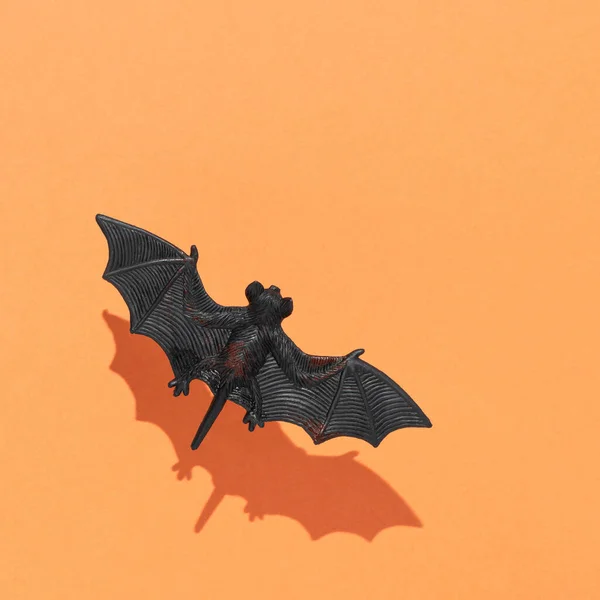 Vliegende Vleermuis Met Zonnescherm Tegen Een Oranje Achtergrond Minimaal Halloween — Stockfoto