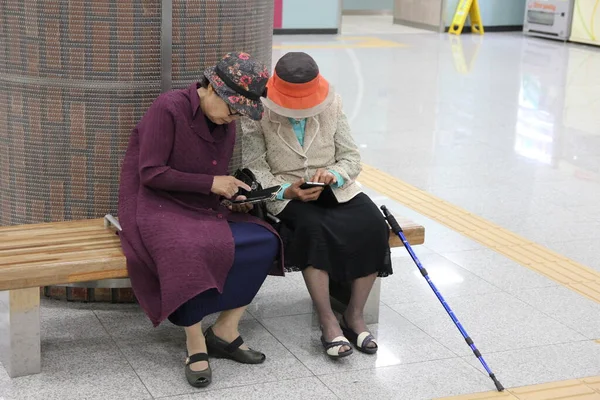 Akıllı telefon kullanan iki yaşlı kadın. Güney Kore