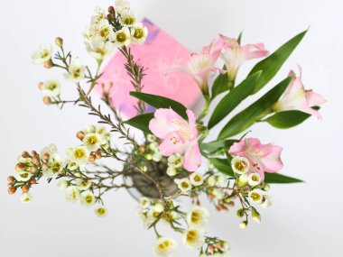 Vazoda bir buket bahar çiçeği ve bir hediye kutusu.