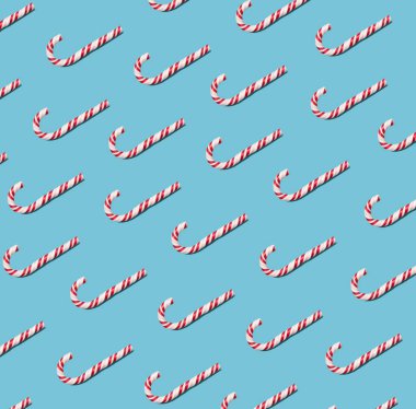 Tatlı kırmızı ve beyaz yuvarlak lolipop pastel mavi arka planda. Desen.