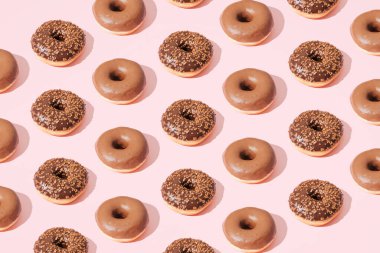 Pembe arka planda çikolatalı çörekler. Desen.