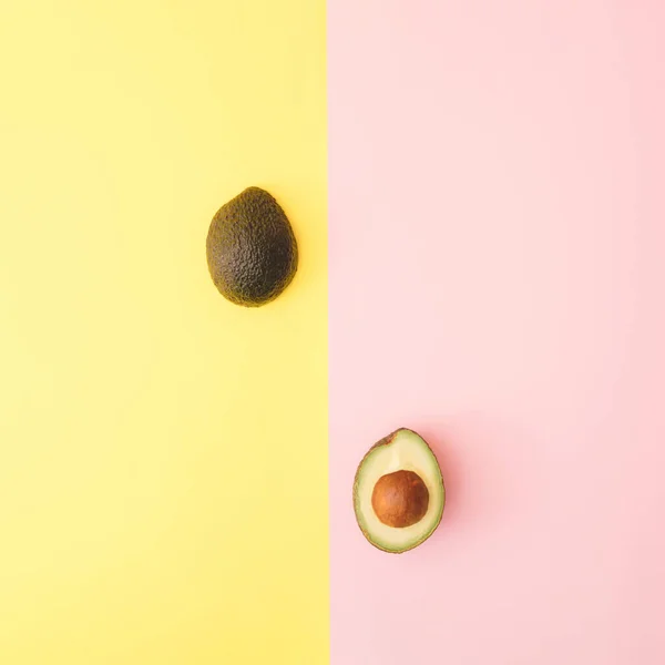 Twee Helften Avocado Een Pastelgele Roze Achtergrond — Stockfoto