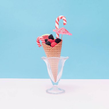 Dondurma külahında farklı şekillerde ve renkte jöle şekerler ve bardakta da sümbül..