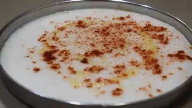 Beyaz dhokla üzerine spatula ile yağ yaymak, beyaz hamurdan yapılmış gujrati kabı beyaz dhokla üzerine spatula ile yayılan yağ, gujrati kabı beyaz hamurdan yapılmış