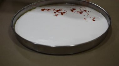 Khaman Dhokla ve Idli 'yi yapmak için beyaz hamura kırmızı biber dökmek