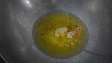 Kaynayan jeera ve menteşe tozu, yeşil biber ve köri yapraklı yağ. 