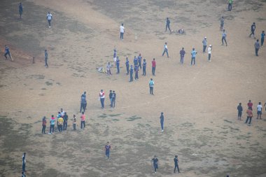 Kilitleme sırasında oyun sahasında kalabalıklaşan ve kriket oynayan insanlar