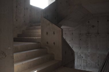 İnşaat alanında güneş ışığı ve gölgesi olan çiğ beton merdivenler.