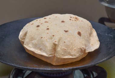 Phulka Chapati (roti) on non stick tawa.Indian Subcontinent food. clipart