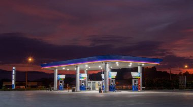 Güneş doğarken benzin istasyonu ve turuncu gökyüzü .