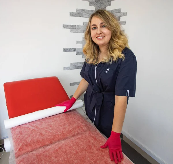 Güzellik uzmanı kanepeye tek kullanımlık bir çarşaf koydu.