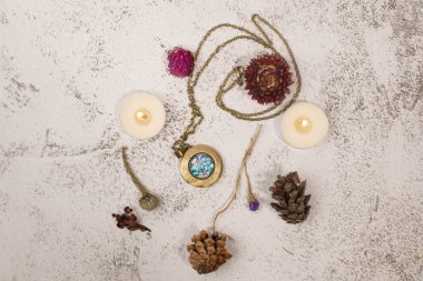 Madalyonu, mumları ve kurumuş çiçekleri olan düz yatak.