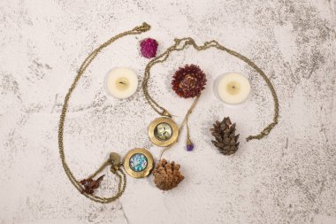 Madalyonu, mumları ve kurumuş çiçekleri olan düz yatak.